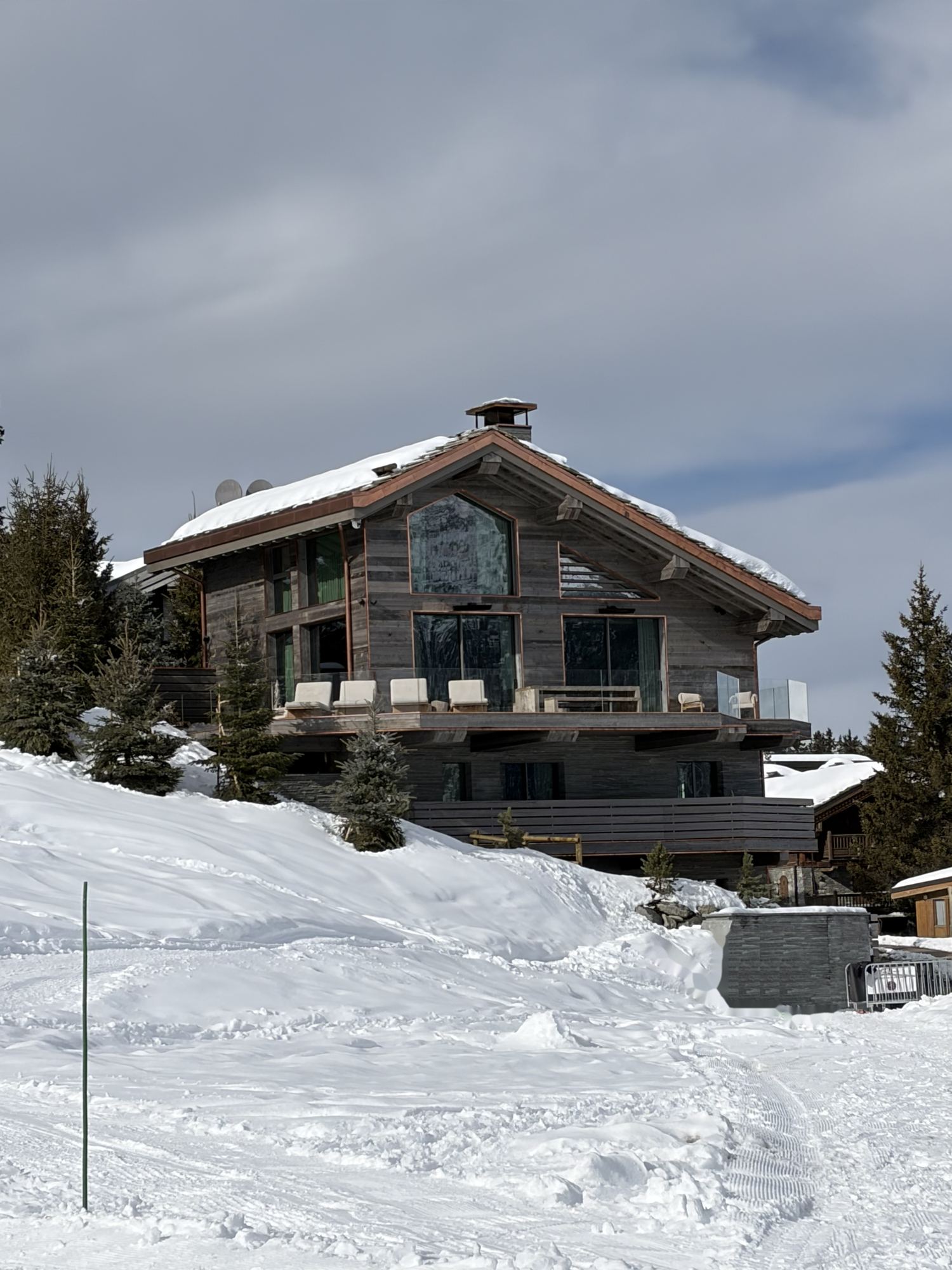 Un chalet de madera y cristal en las laderas nevadas de Courchevel