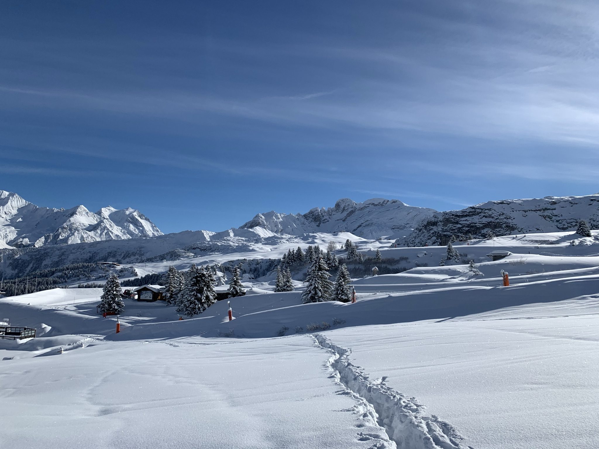 Uma trilha na neve fresca rumo aos chalés e picos de Courchevel