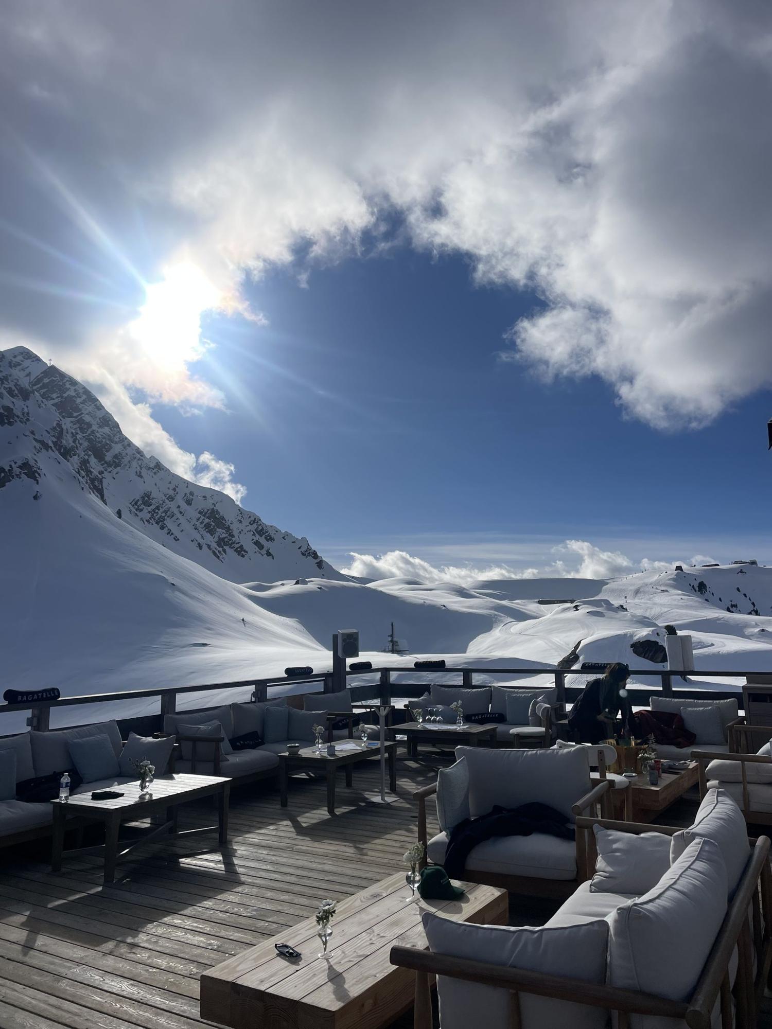 A sunny terrace with lounge sofas above Courchevel